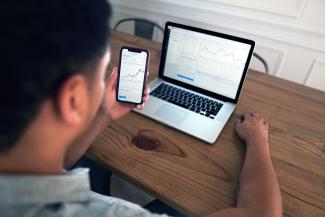 person holding iphone 6 near macbook pro by Joshua Mayo courtesy of Unsplash.