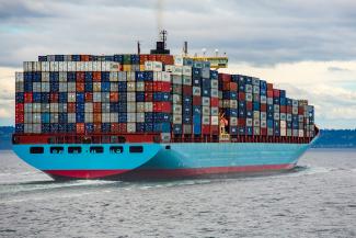 blue and red cargo ship on sea during daytime by Ian Taylor courtesy of Unsplash.