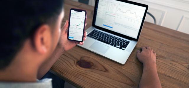 person holding iphone 6 near macbook pro by Joshua Mayo courtesy of Unsplash.
